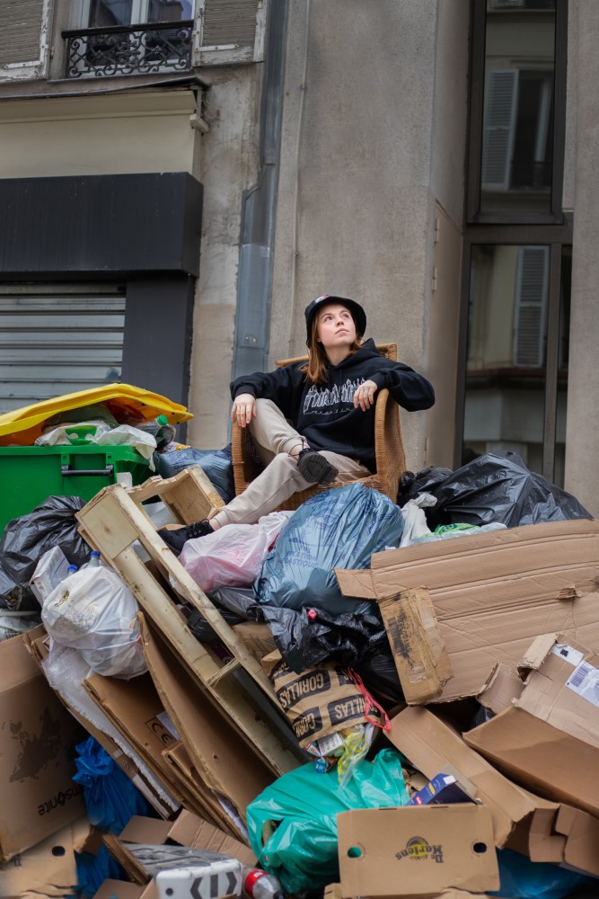 Una mujer en una silla sobre una montaña de basura.