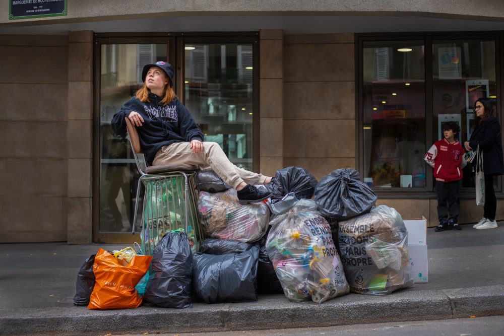 Una mujer sentada sobre una montaña de basura .