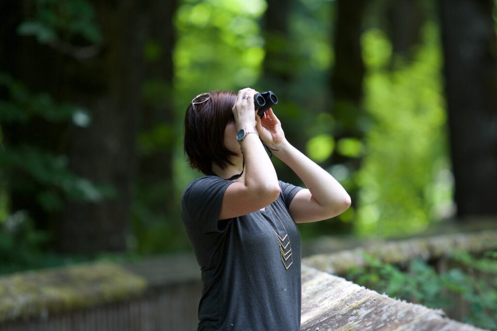 Mujer en el bosque con binoculares 