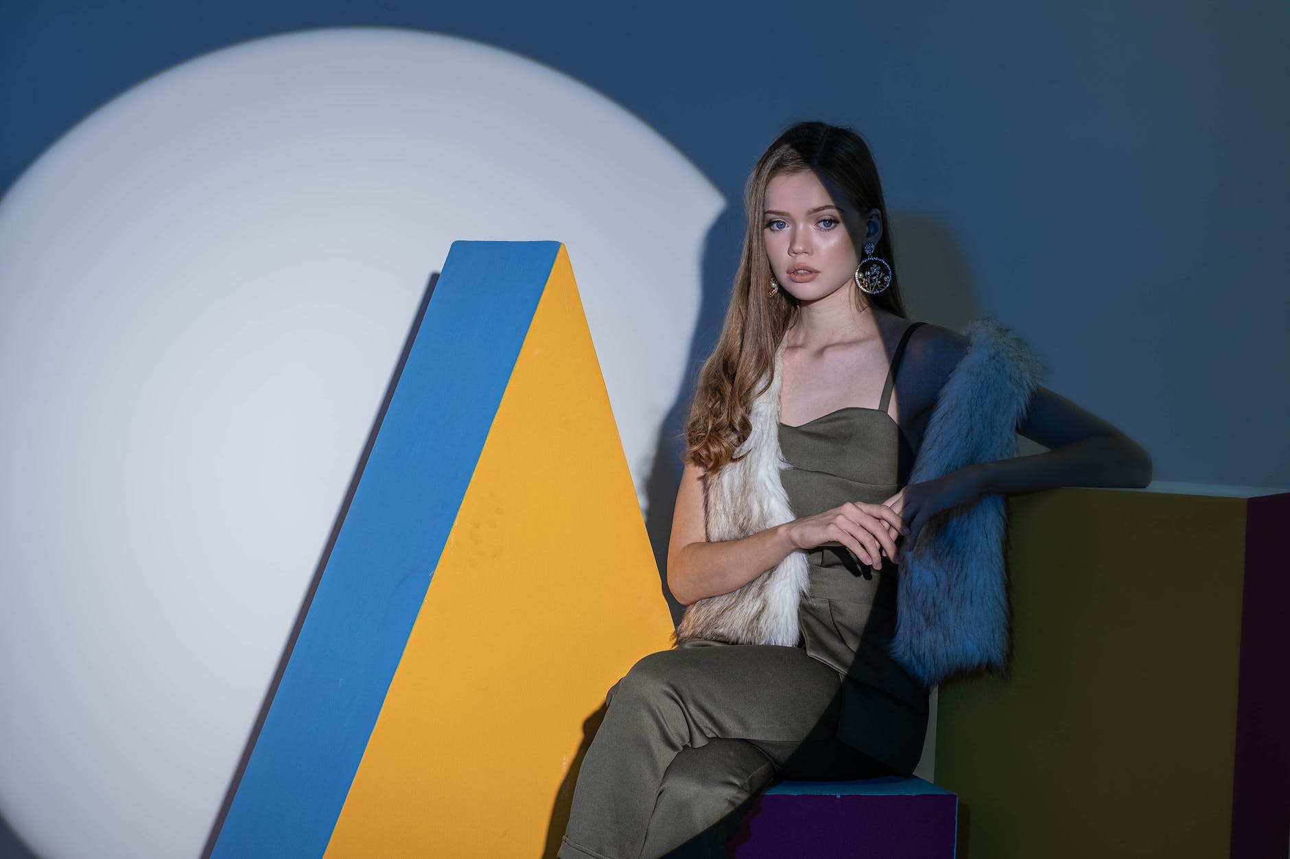 blond woman posing with yellow and blue geometric decoration