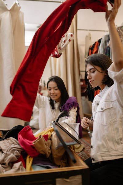 Dos jovenes comprando ropa de segunda mano en una tienda sustentable