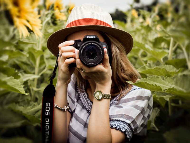 Mujer joven tomando foto con cámara Canon