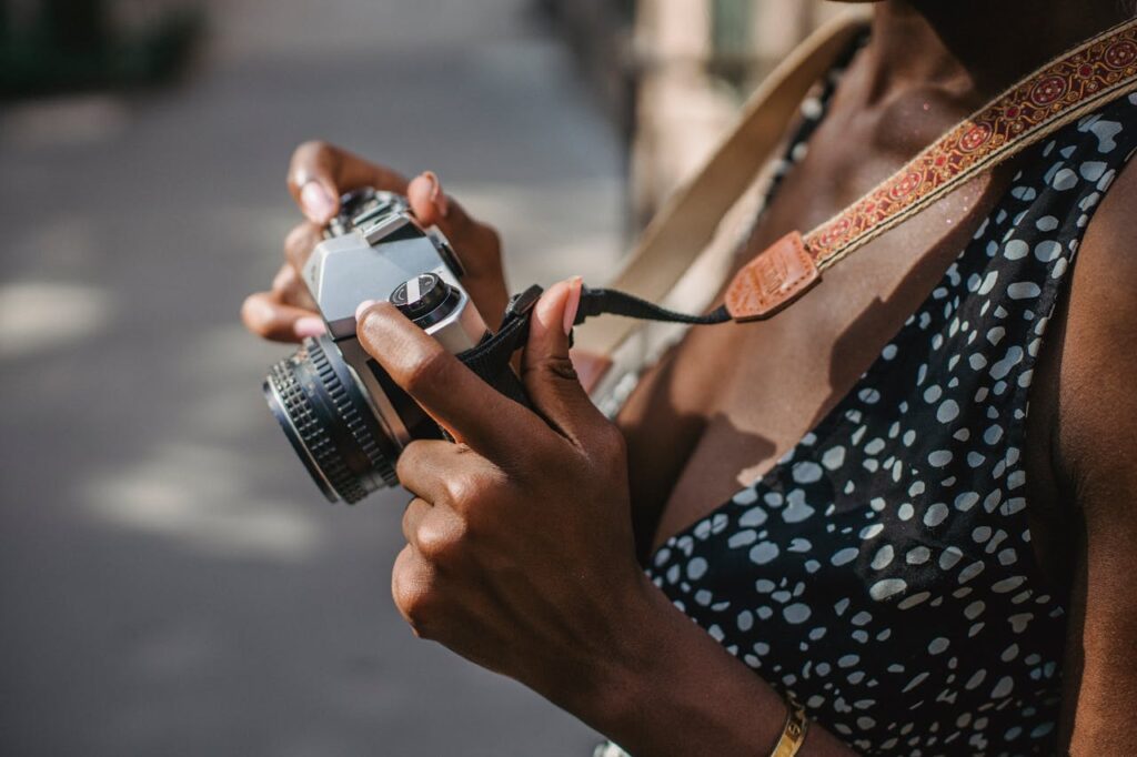 Cámara colgando de una correa elegante mientras un fotógrafo camina por la ciudad.